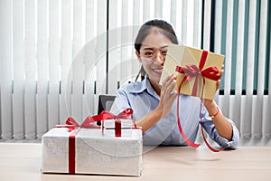 Asian woman holding a gift box Glad to be the giver of surprise with excitement, joy and smiles on the holidays, Christmas,