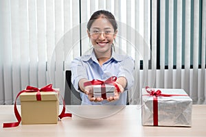 Asian woman holding a gift box Glad to be the giver of surprise with excitement, joy and smiles on the holidays, Christmas,