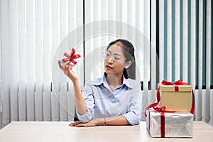 Asian woman holding a gift box Glad to be the giver of surprise with excitement, joy and smiles on the holidays, Christmas,