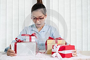 Asian woman holding a gift box Glad to be the giver of surprise with excitement, joy, and smiles on the holidays, Christmas,