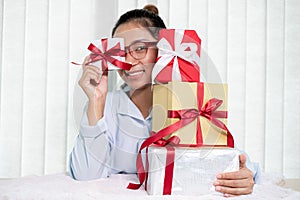 Asian woman holding a gift box Glad to be the giver of surprise with excitement, joy, and smiles on the holidays, Christmas,