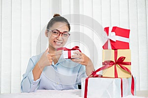 Asian woman holding a gift box Glad to be the giver of surprise with excitement, joy, and smiles on the holidays, Christmas,