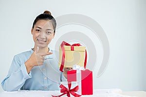 Asian woman holding a gift box Glad to be the giver of surprise with excitement, joy, and smiles on the holidays, Christmas,