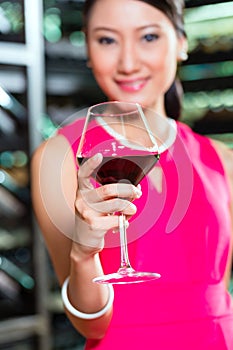 Asian woman holding glass of wine
