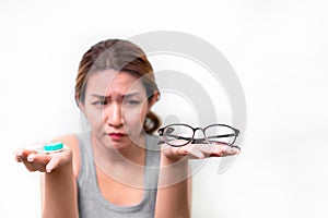 Asian woman holding glasses and contact lens on white background, Selective focus on glasses , myopia and eyesight problem concept