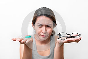 Asian woman holding glasses and contact lens on white background, Selective focus on glasses , myopia and eyesight problem concept