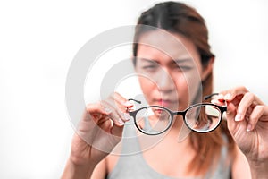Asian woman holding glasses on white background, Selective focus on glasses , myopia and eyesight problem concept