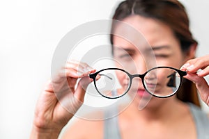 Asian woman holding glasses on white background, Selective focus on glasses , myopia and eyesight problem concept