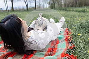 Asian woman holding healthy Lovely bunny easter fluffy rabbits on green field.