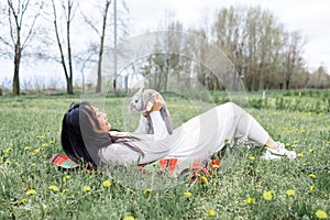 Asian woman holding healthy Lovely bunny easter fluffy rabbits on green field. The Easter hares.