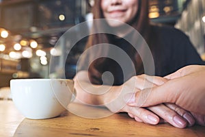 Asian woman holding a man`s hand with feeling love and warmness