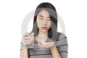 Asian woman holding medicine feels sick