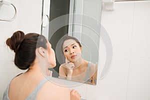 Asian woman holding a mirror, touch and worrying about her face