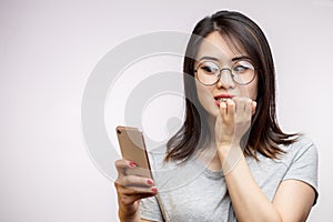 Asian woman holding modern smart phone isolated over white background in studio