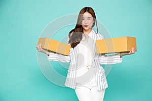 Asian woman holding package parcel box isolated on light green background, Delivery courier and shipping service concept