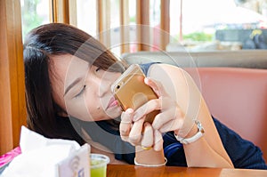 Asian woman holding phone recline