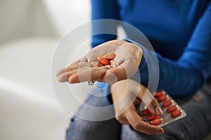 Asian woman holding pills and medicine in hand