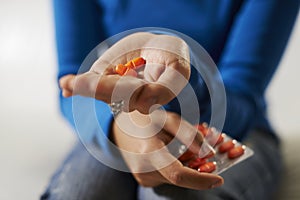 Asian woman holding pills and medicine in hand