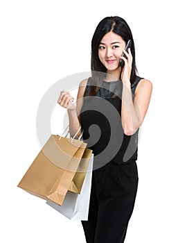 Asian woman holding shooping bag and listen mobile phone photo