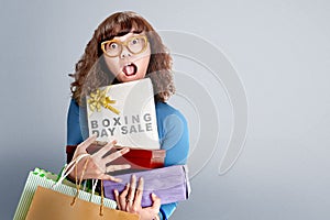 Asian woman holding shopping bags and gift box with Boxing Day Sale text