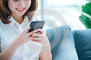 Asian woman holding smartphone with E-commerce Shopping online website Reading Online Article, Blog, vlog. Young Woman hands