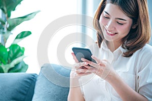 Asian woman holding smartphone with E-commerce Shopping online website Reading Online Article, Blog, vlog. Young Woman hands
