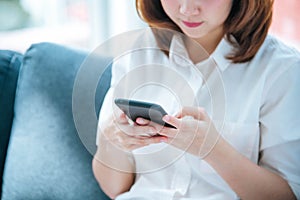 Asian woman holding smartphone with E-commerce Shopping online website Reading Online Article, Blog, vlog. Young Woman hands