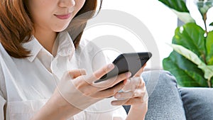 Asian woman holding smartphone with E-commerce Shopping online website Reading Online Article, Blog, vlog. Young Woman hands