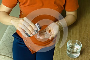 Asian woman holding vitamin capsules in her fingertips