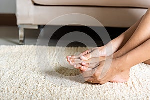 Asian woman holds her toe injury feeling pain her foot at home