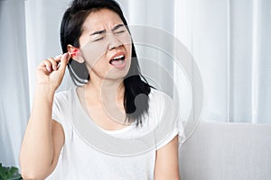 Asian woman hurts from cleaning  ear wax by cotton bud that put too deep inside her ear