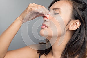 The asian woman hurts her nose because she has cold.