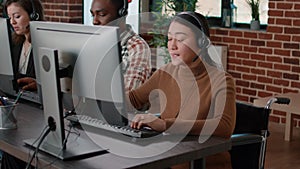 Asian woman with impairment talking to clients at call center