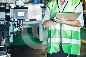 Asian woman is industrial engineer or QC team holding the clipboard