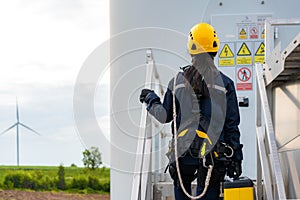 Asian woman Inspection engineer preparing and progress check of a wind turbine with safety in wind farm in Thailand