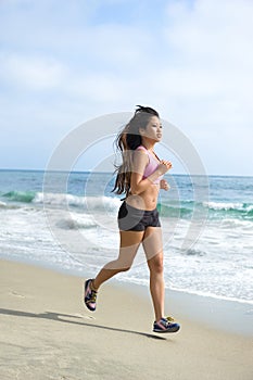 Asian woman jogging at beach