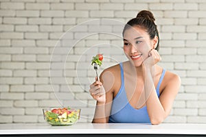 Asian woman in joyful postures with salad bowl on the side