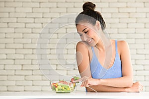 Asian woman in joyful postures with salad bowl on the side