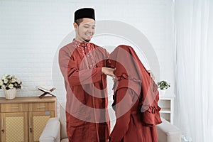 Asian woman kissing hands to his husband for apologize when celebrate happy Eid Ul-Fitr