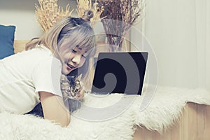 Asian woman lady in casual dress lay down on bed and relax with cat and play on laptop,process in vintage style