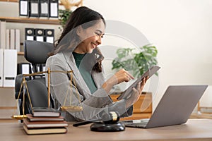 asian woman lawyer working and judge in a courtroom the gavel, working with tablet and laptop and digital tablet