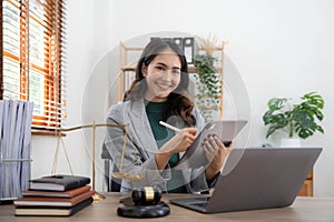 asian woman lawyer working and judge in a courtroom the gavel, working with tablet and laptop and digital tablet