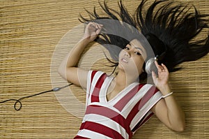 Asian woman laying down listening to music