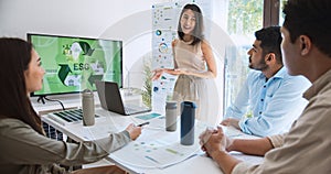 Asian woman lead young group of multiethnic businesspeople in team meeting, using laptop computer for ESG topic presentation