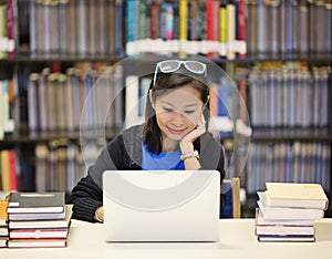 Asiático una mujer en biblioteca computadora portátil 