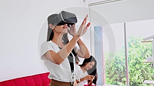 Asian woman lifestyle at home with Thai friend. Social distancing. Wearing virtual reality headset