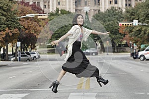 Asian Woman in lifestyle locations crossing the street street in front of Capital building in Austin, Texas