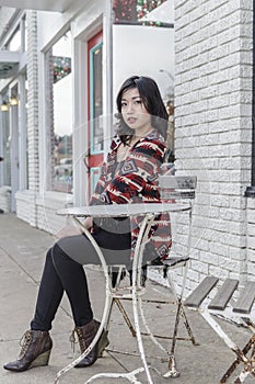 Asian Woman in lifestyle locations sitting at a table on the street