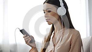 Asian woman listening music in headphones, loving radio station, enjoyment