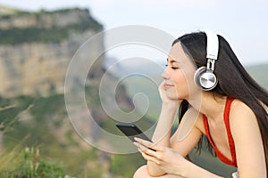 Asian woman listening to music relaxing outdoors